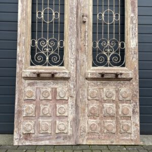 Antieke dubbele deuren met sierlijk smeedijzer