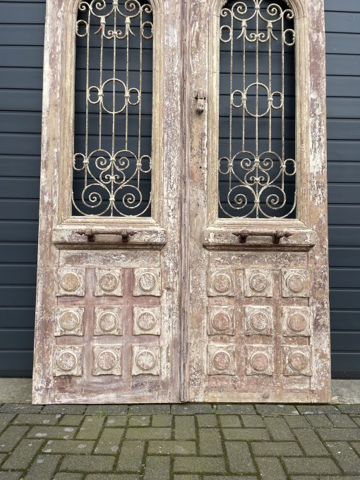 Antieke dubbele deuren met sierlijk smeedijzer
