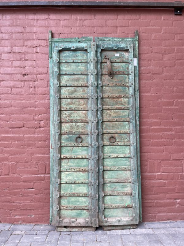 Antique double doors with weathered green paint, solid wood, rustic hardware, vooraanzicht.