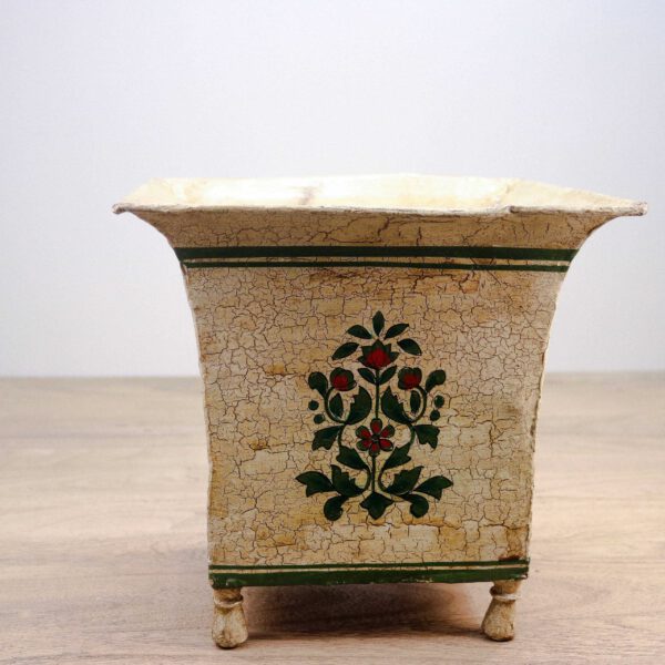 Vintage wooden planter with cracked paint and floral design, vooraanzicht.